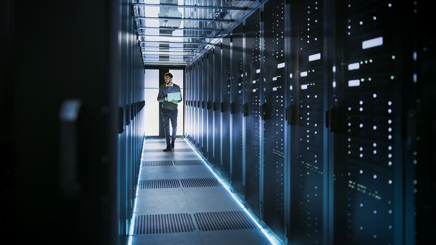 Technician working with his laptop on data center servers.