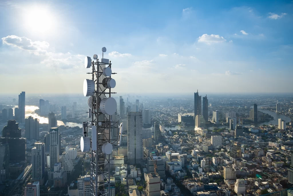 Figure 1: Telecommunication tower with 5G cellular network antenna on city background 